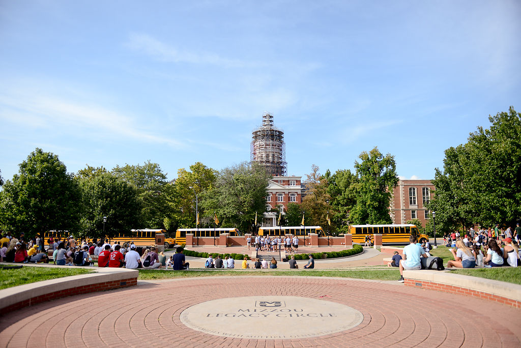 Incoming business students wait at Friday Traditions Plaza to board school buses